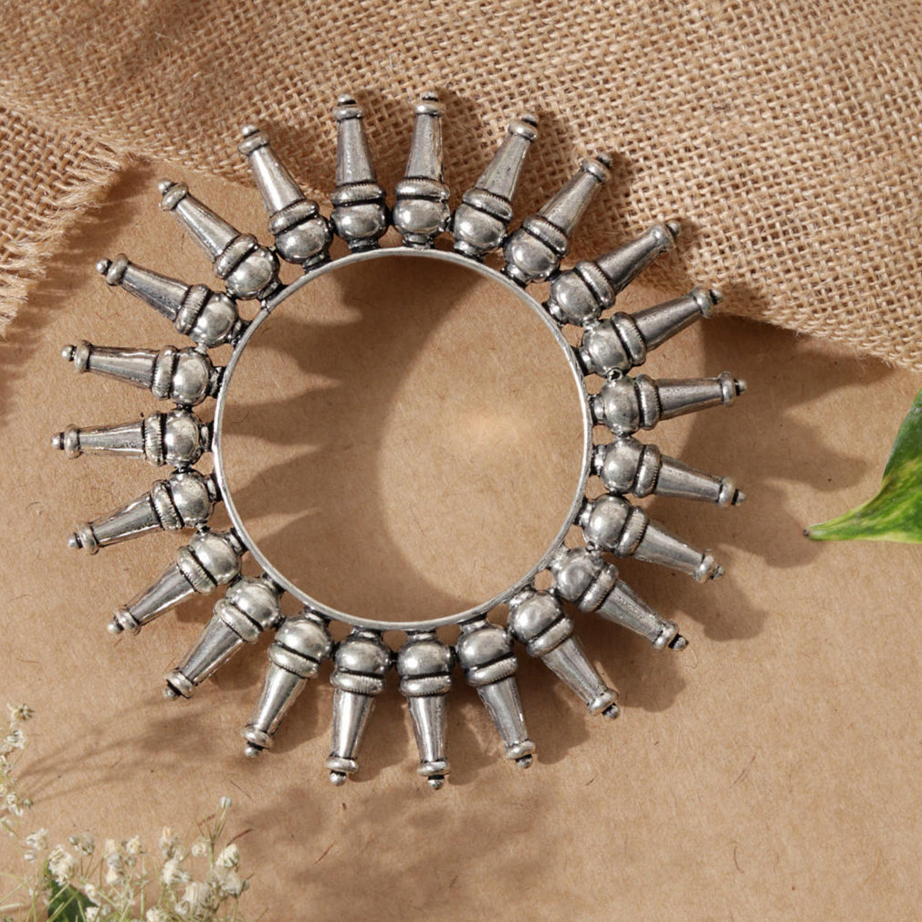 A silver-plated oxidized tribal kada bangle with a rays pattern