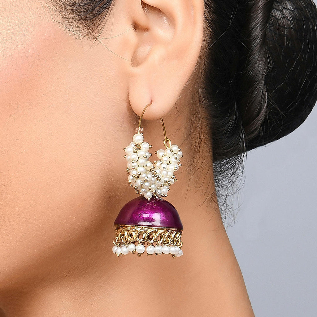 A person wearing a Meenakari Hoop Jhumki Earring with a pink enamelled drop and pearl bead detailing.
