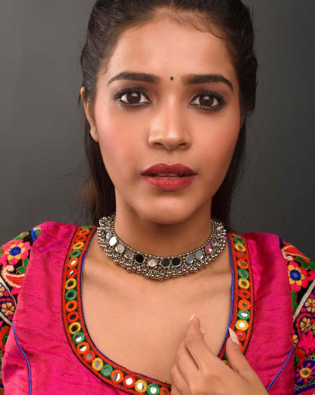 model wearing a silver oxidized choker necklace with mirrored ghungroo details with traditional dress
