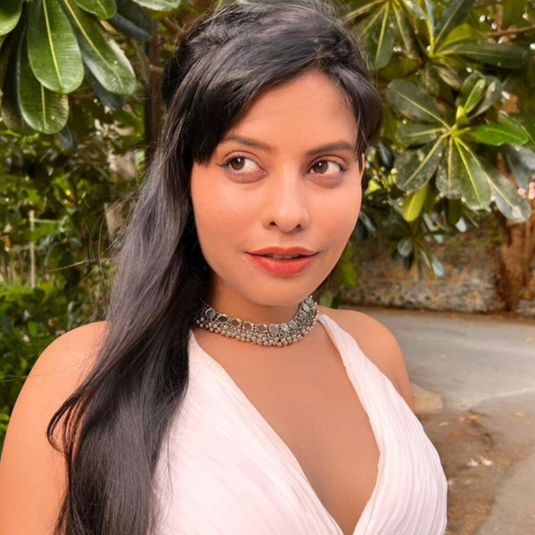 model wearing a silver oxidized choker necklace with mirrored ghungroo details.