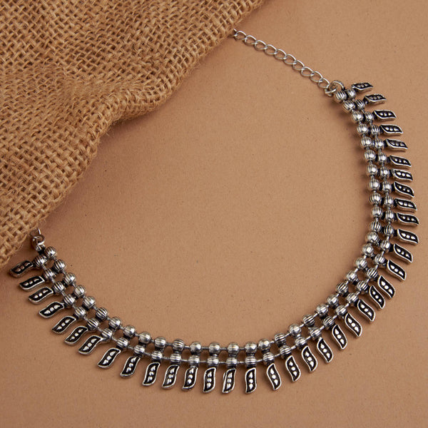 A silver-toned antiqued beaded choker necklace displayed on a brown background.