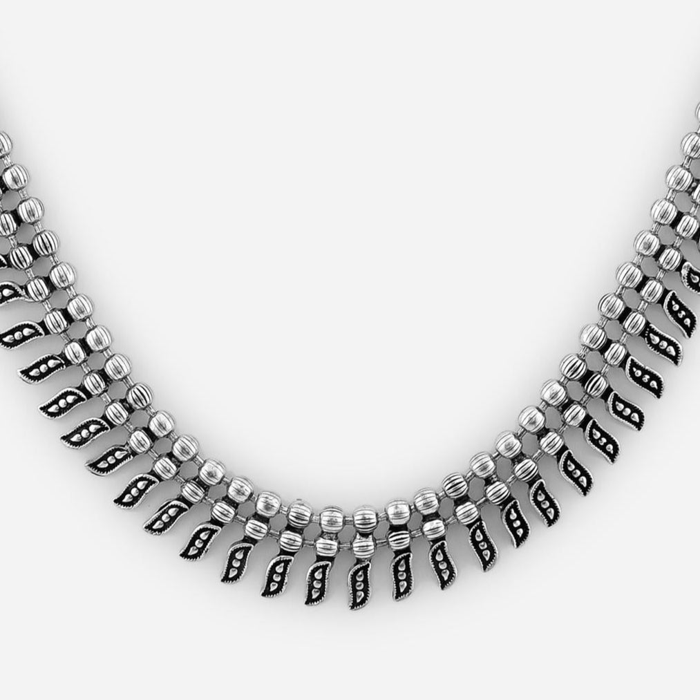 A silver-toned antiqued beaded choker necklace close-up displayed on a white background.