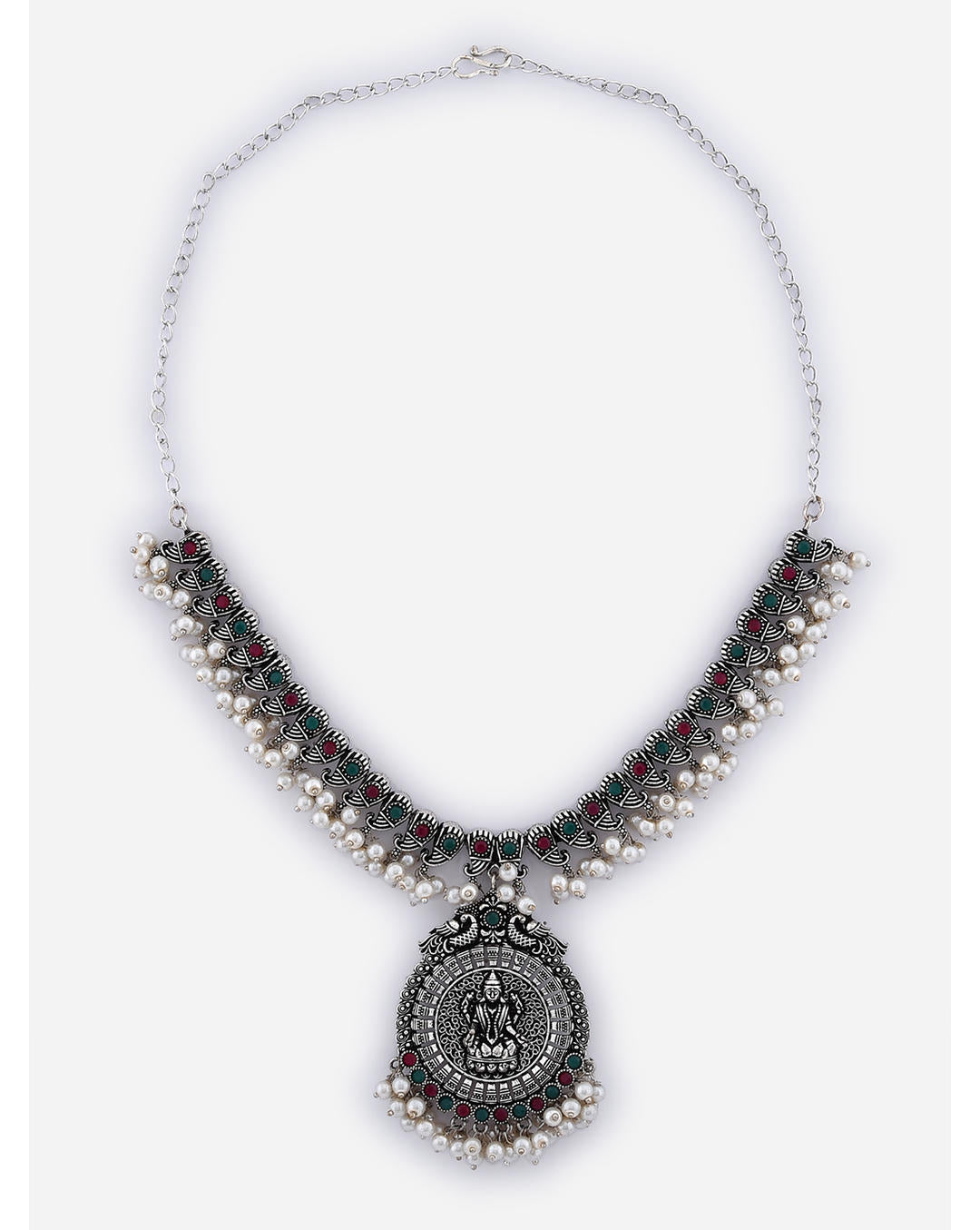 A silver-plated oxidised temple jewellery set with white pearls and green and red stones, featuring a detailed pendant and a pair of earrings.