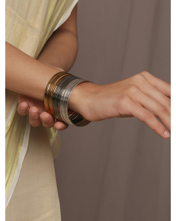 A set of 18 metal bangles in gold, silver, and gunmetal colors