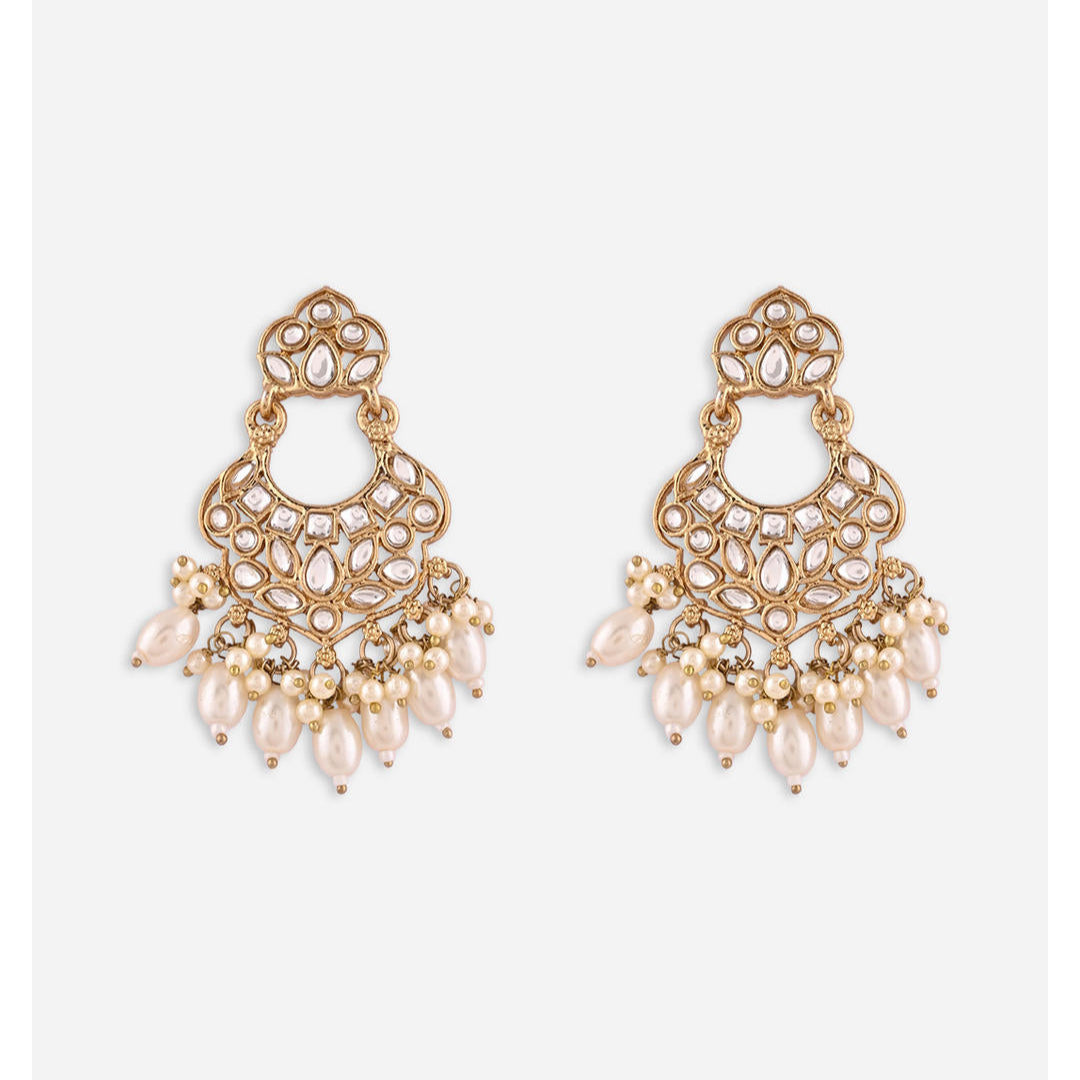 A pair of gold-plated white kundan pearl chandbali earrings with intricate designs and drop-shaped pearls.