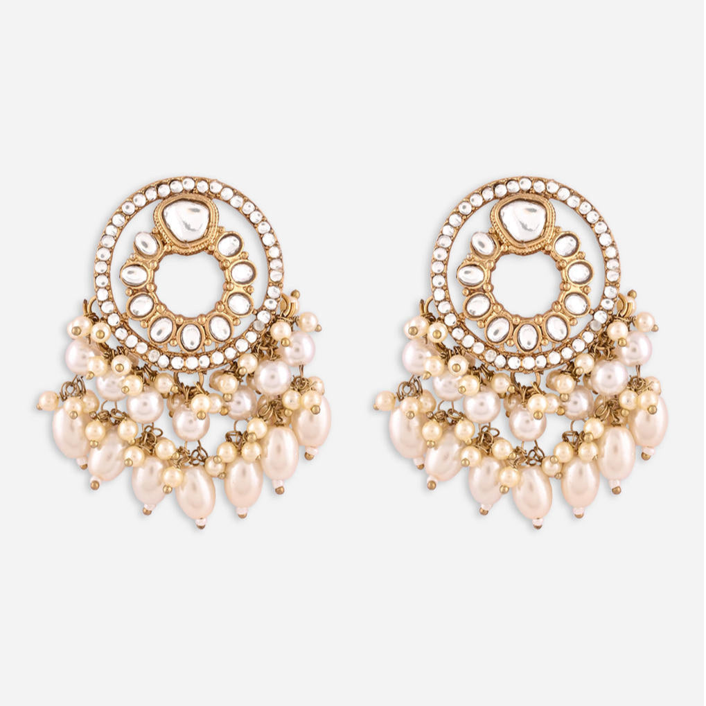 A pair of gold-plated white kundan pearl drop earrings with intricate designs and multiple pearl droplets.