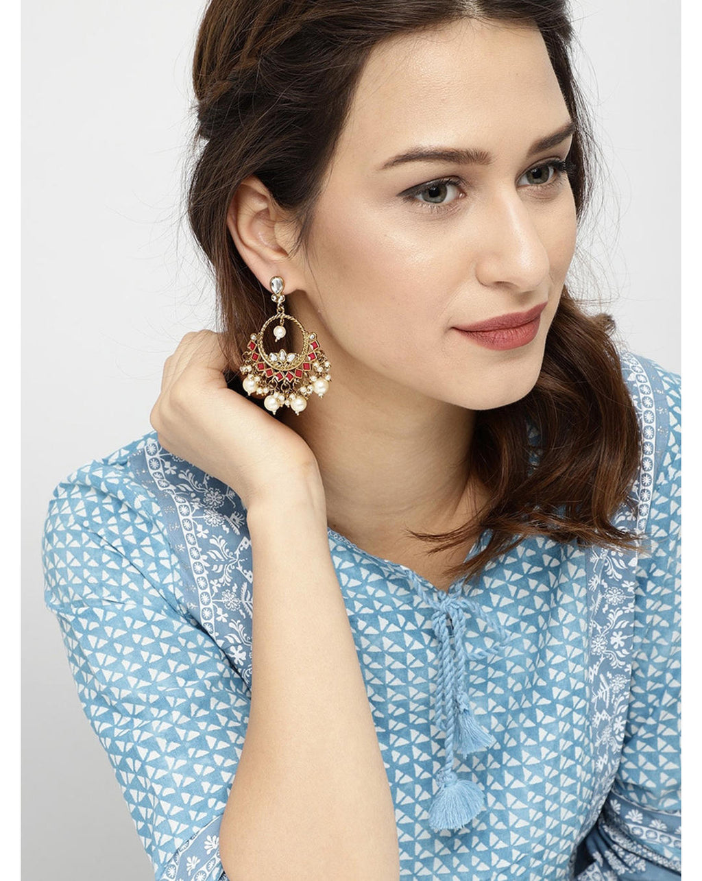 Model Wearing Vermilion Round Chandbali Earrings with red enamel accents, kundan stones and pearl drops, handcrafted traditional Indian ethnic jewellery.