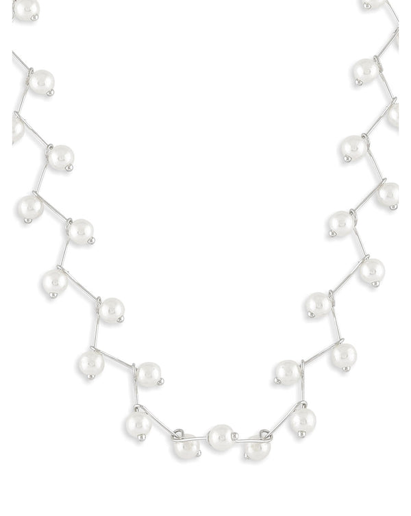 A choker necklace with a leaf pattern interspersed with white pearls, set against a silver-toned finish.