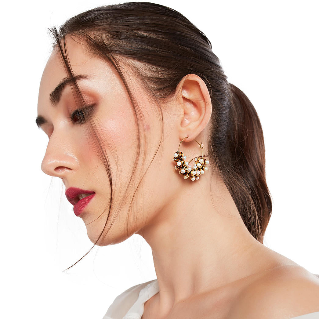 gold-plated hoop earring adorned with white pearls.