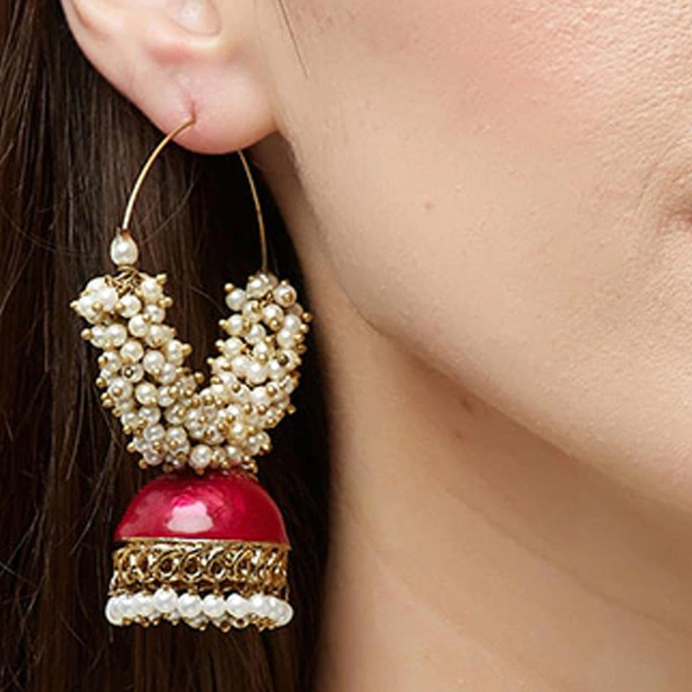 A gold-plated hoop earring with white beads and red enamel detailing