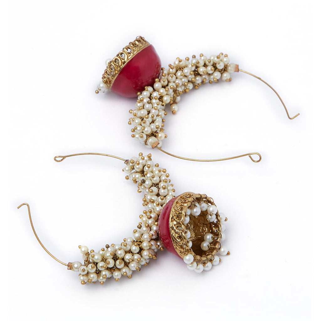 A gold-plated hoop earring with white beads and red enamel detailing