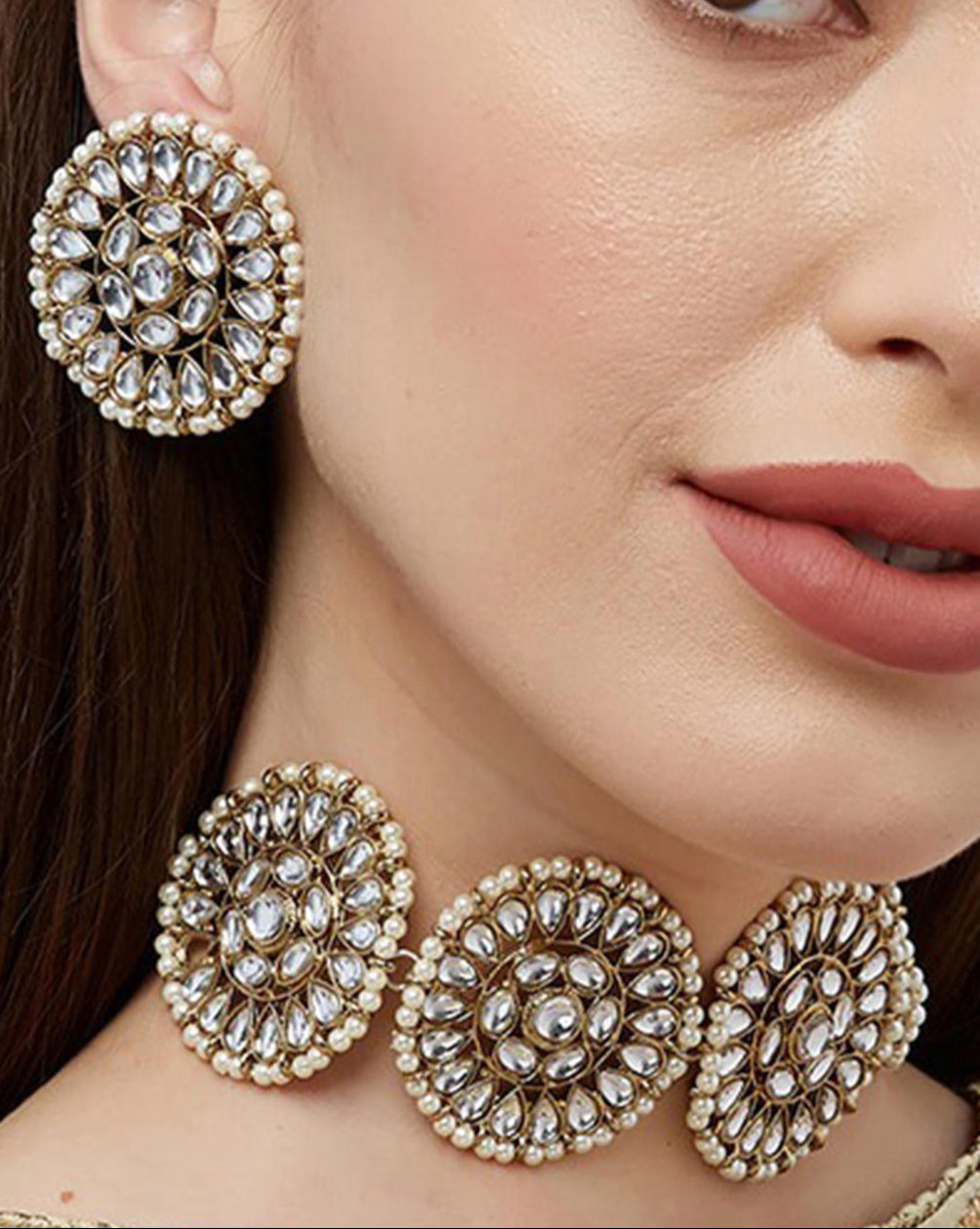 gold-plated choker necklace and matching earrings embellished with kundan stones.
