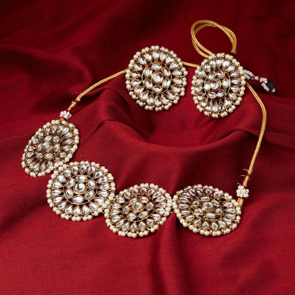 gold-plated choker necklace and matching earrings embellished with kundan stones.