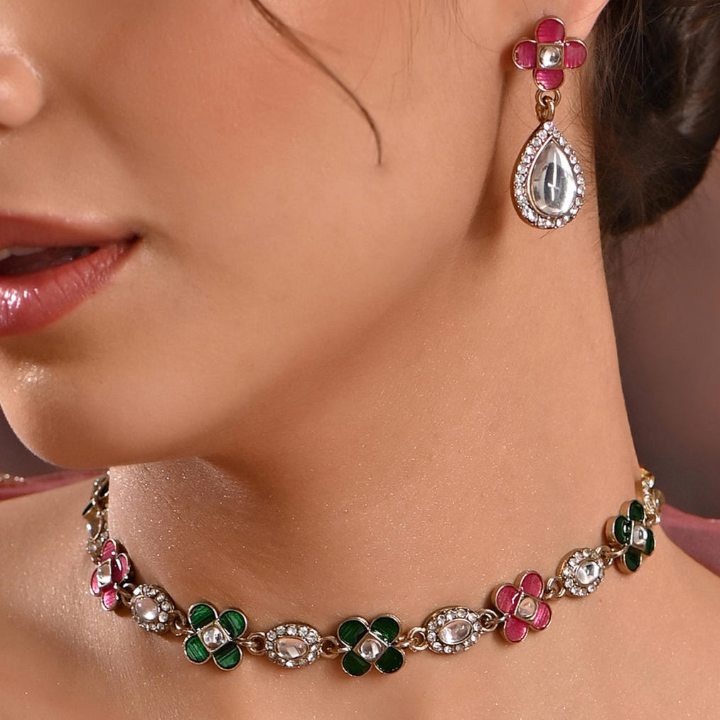 A woman wearing a multicolored floral traditional jewelry set with kundan and meenakari details.