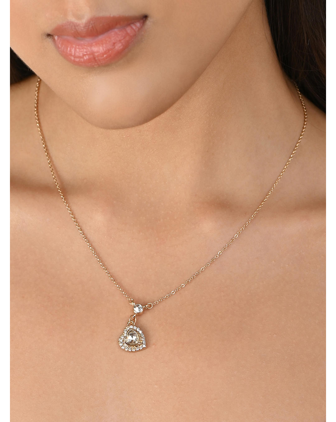 A woman wearing a gold plated floral charm necklace studded with CZ stones.