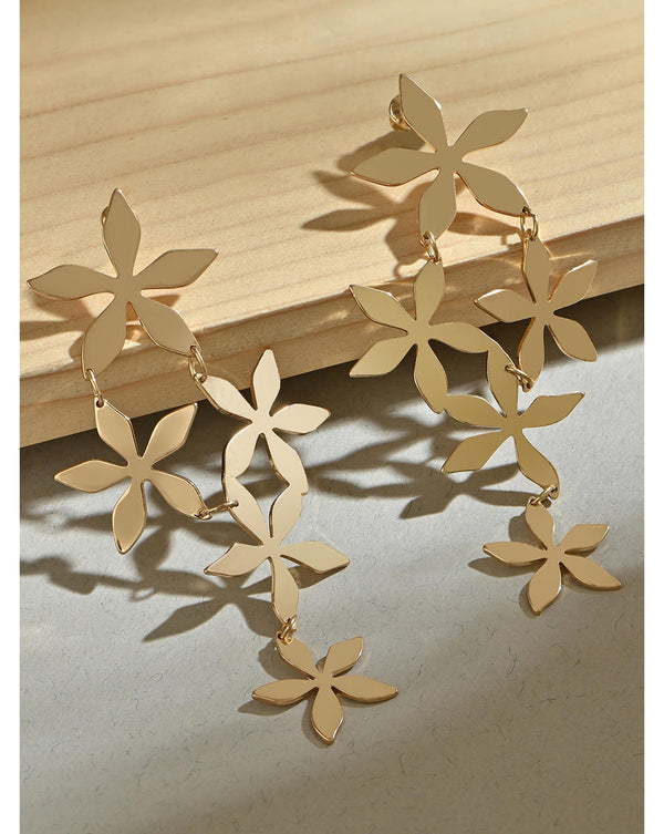 Gold-toned multi floral drop earrings displayed against a wooden background.