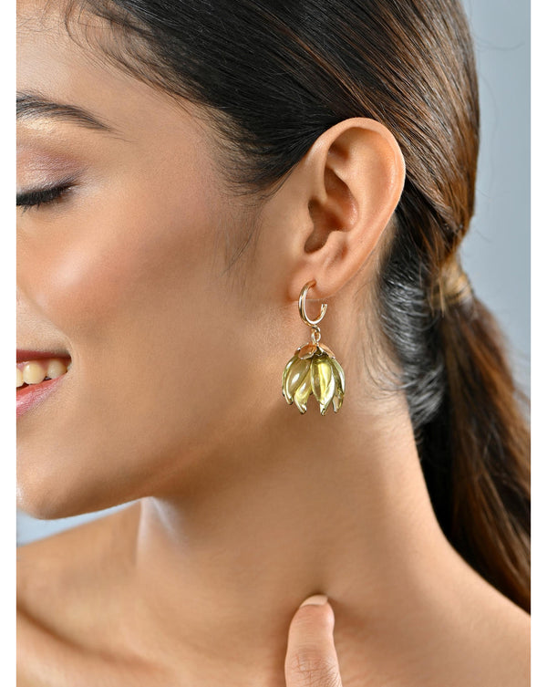 A woman wearing gold-plated translucent verdant leaf dangle earrings with fish hook closures.