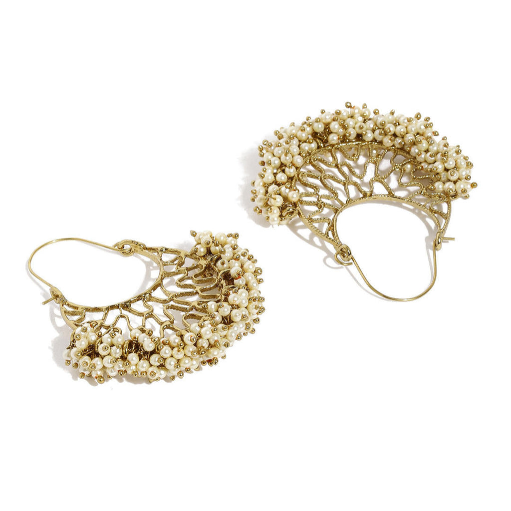 A pair of gold-plated chandbali earrings with white beads arranged in a crescent pattern