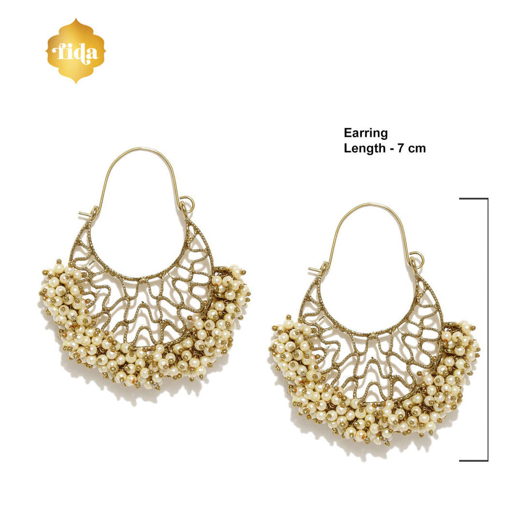 A pair of gold-plated chandbali earrings with white beads arranged in a crescent pattern dimension